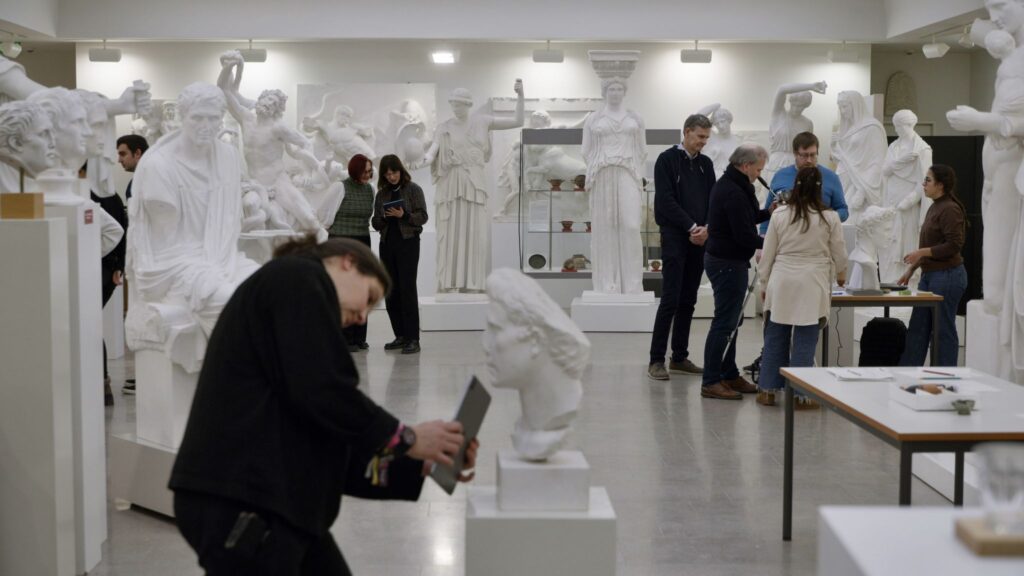 Person scannt mit Tablet eine Statue.