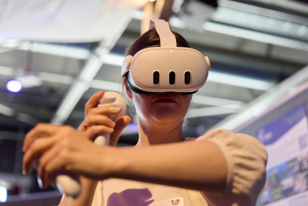 Person mir VR-Brille auf und Controllern in der Hand.