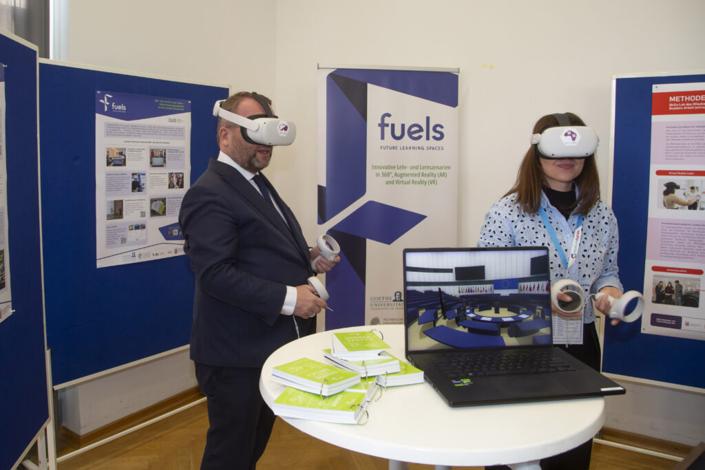 Timon Gremmels probiert die VR-Brille aus. Im Vordergrund ist ein Laptop, welcher den Plenarsaal des EU-Parlaments in VR zeigt.